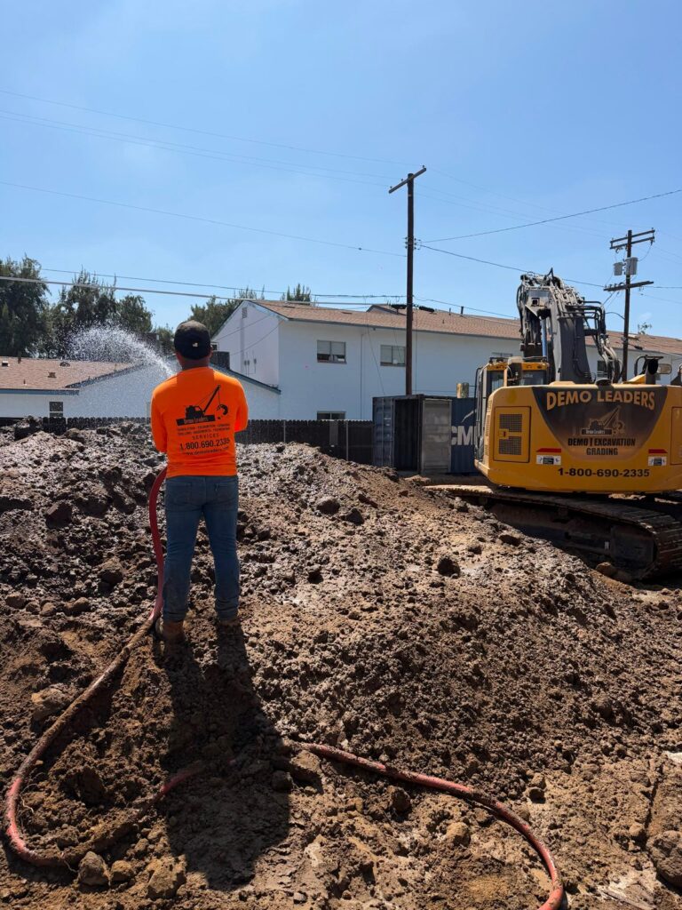 Crew member managing soil moisture during excavation R&R services _ Demoleaders