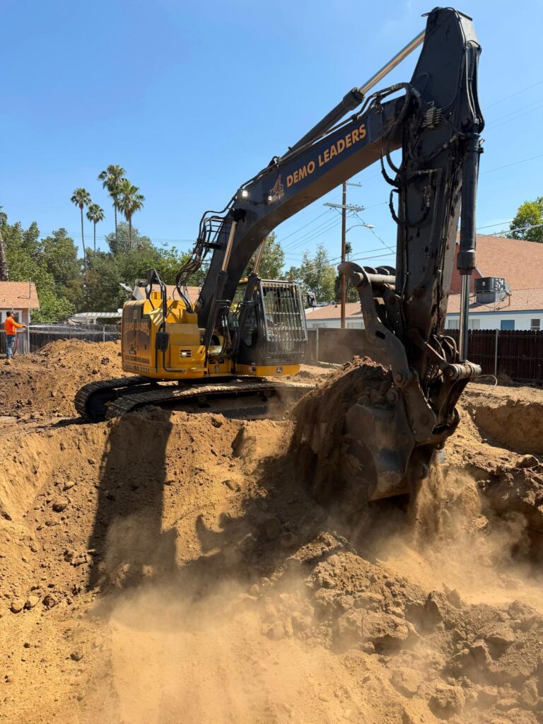 Excavator removing soil during Remove and Replace excavation for new build preparation _ Demoleaders