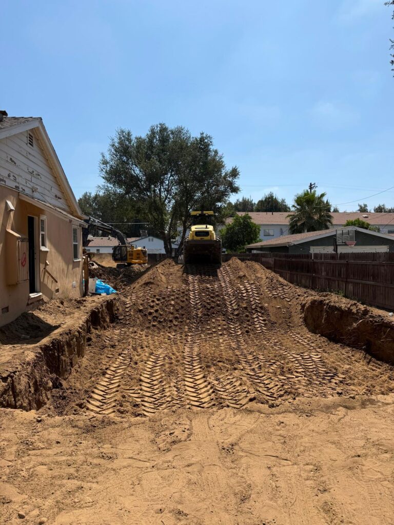 Heavy equipment excavating and moving soil for re-compact preparation _ Demoleaders